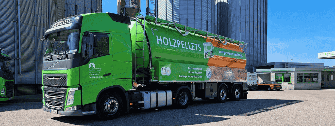Grüner Silolastzug von Raiffeisen Bio-Brennstoffe nach Beladung mit Holzpellets vor hohen Lagersilos an einem sonnigen Standort.