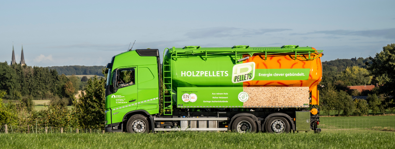 Ein LKW der Raiffeisen Bio-Brennstoffe fährt über eine ländliche Straße und ist auf dem Weg zur Auslieferung von Holzpellets. Das Bild dient als Banner für die Logistik-Seite.