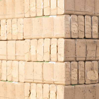 Gestapelte rechteckige RUF‑Holzbriketts auf einer Palette, eng geschichtet und in Folie gebündelt.