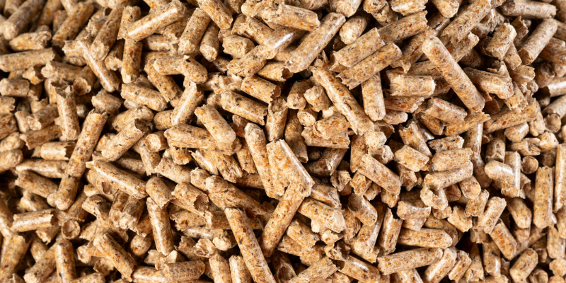 Detailaufnahme von hochwertigen Holzpellets. Die kompakte und gleichmäßige Struktur zeigt die sorgfältige Verarbeitung und die Qualität des Brennstoffs.